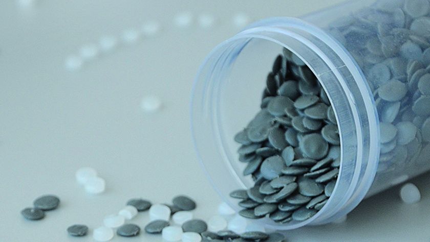 Umgekippte Plastikdose mit Rezyklatteilchen